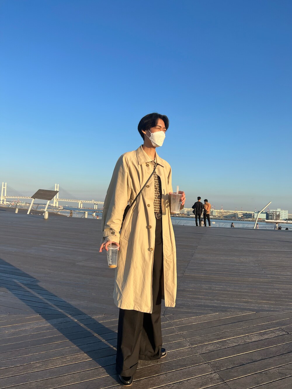 ベージュ系のステンカラーコートを着用したメンズの秋コーディネートの2枚目の写真