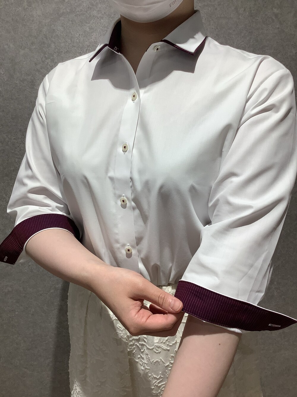 ホワイト系のビジネスシャツを着用したレディースの夏コーディネートの2枚目の写真