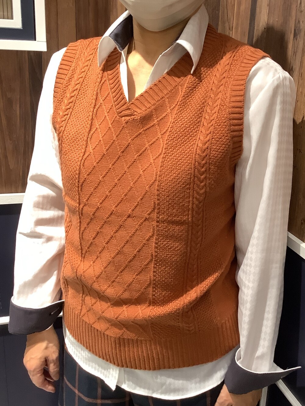 オレンジ系のベスト、ホワイト系のビジネスシャツを着用したレディースの秋コーディネートの2枚目の写真