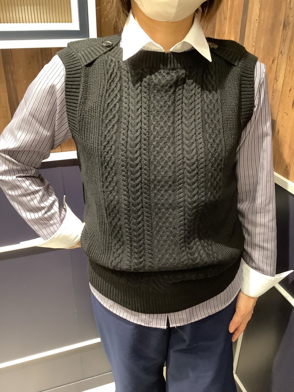 グレー系のビジネスシャツ、ブラック系のニット/セーターを着用したレディースの秋コーディネートの2枚目の写真