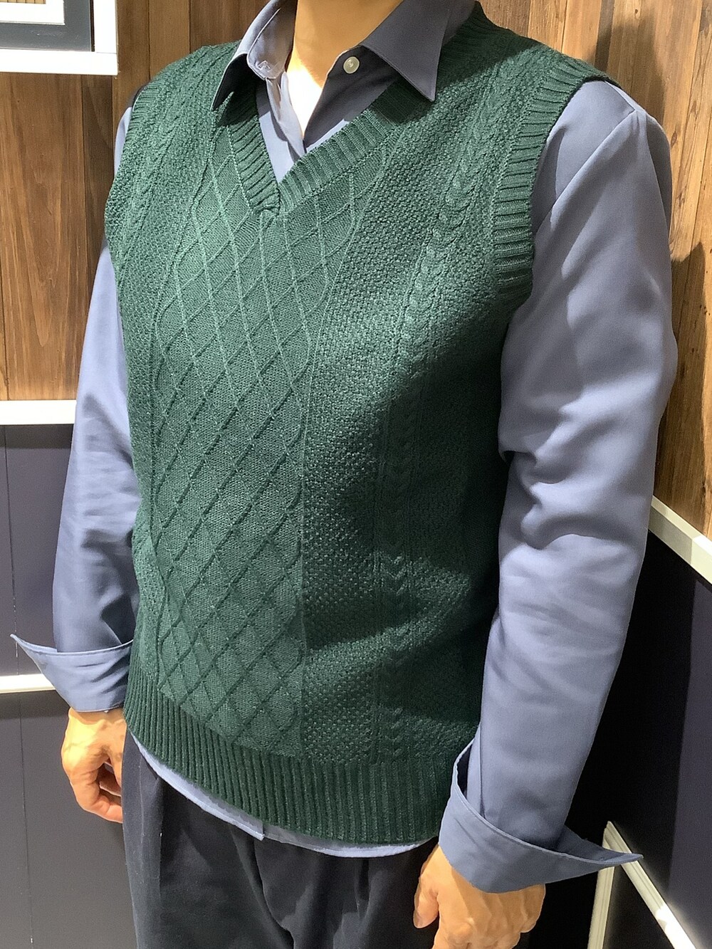 グリーン系のベスト、ブルー系のビジネスシャツを着用したレディースの秋コーディネートの2枚目の写真