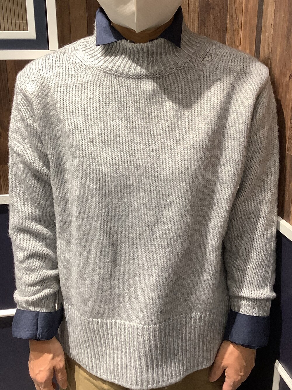 グレー系のニット/セーター、ブルー系のシャツ/ブラウスを着用したレディースの秋コーディネートの2枚目の写真