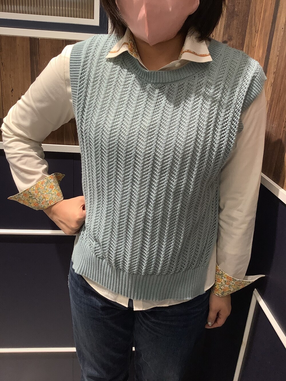 グリーン系のベスト、イエロー系のビジネスシャツを着用したレディースの春コーディネートの2枚目の写真