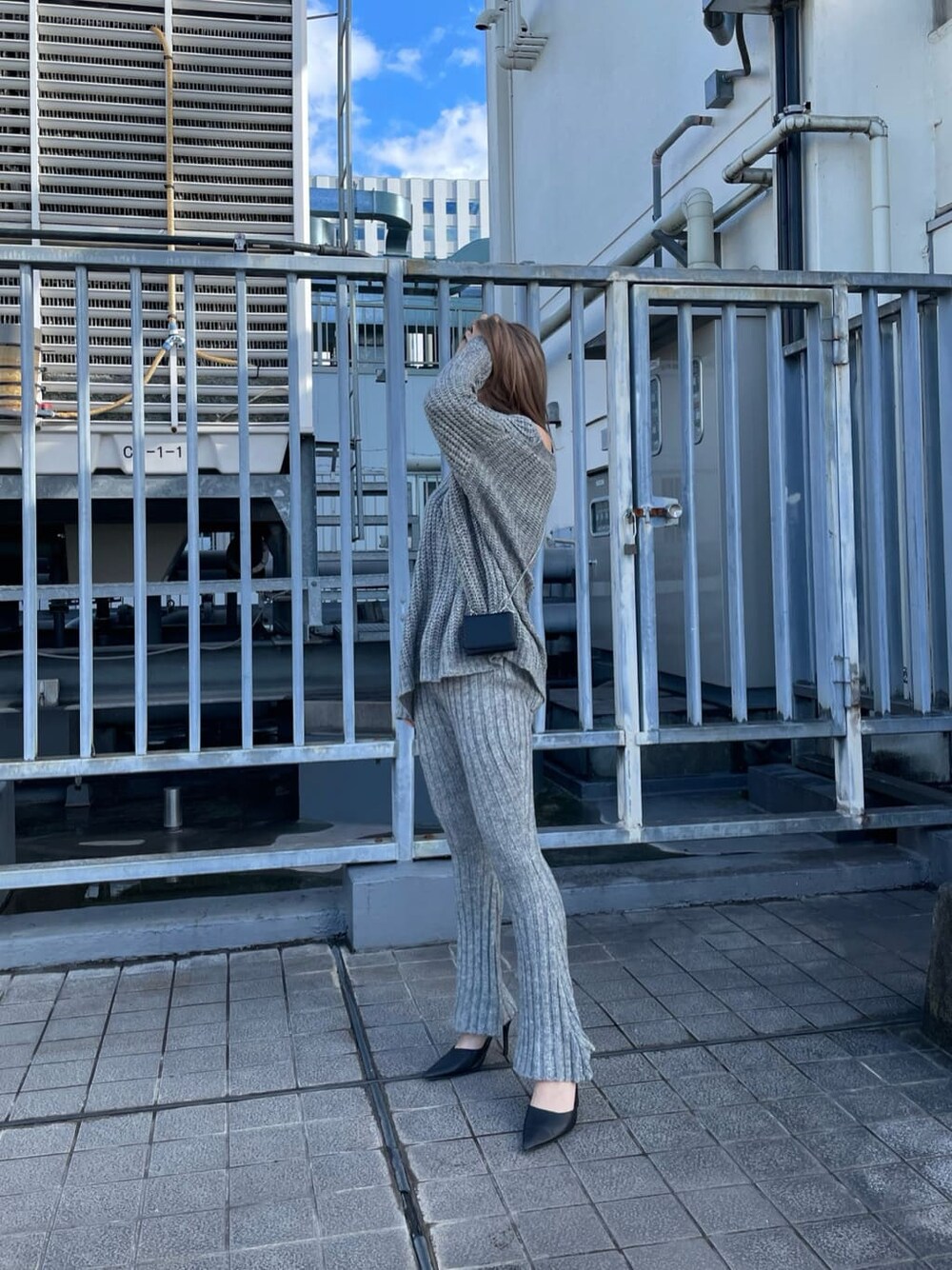 グレー系のその他パンツ、ブラック系のパンプス、グレー系のニット/セーターを着用したレディースの冬コーディネートの2枚目の写真