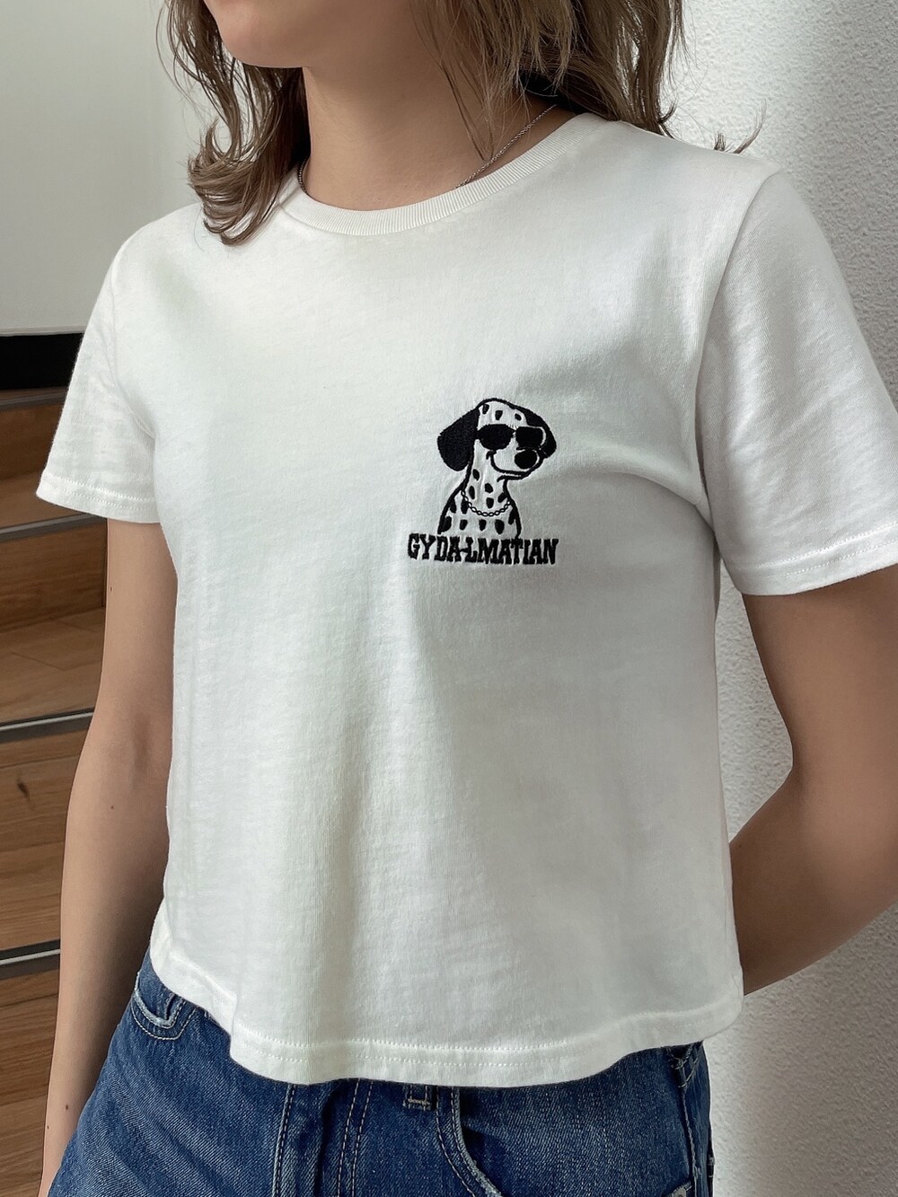 ホワイト系のTシャツ/カットソー、ブルー系のデニムパンツ、ホワイト系のパンプスを着用したレディースの春コーディネートの4枚目の写真