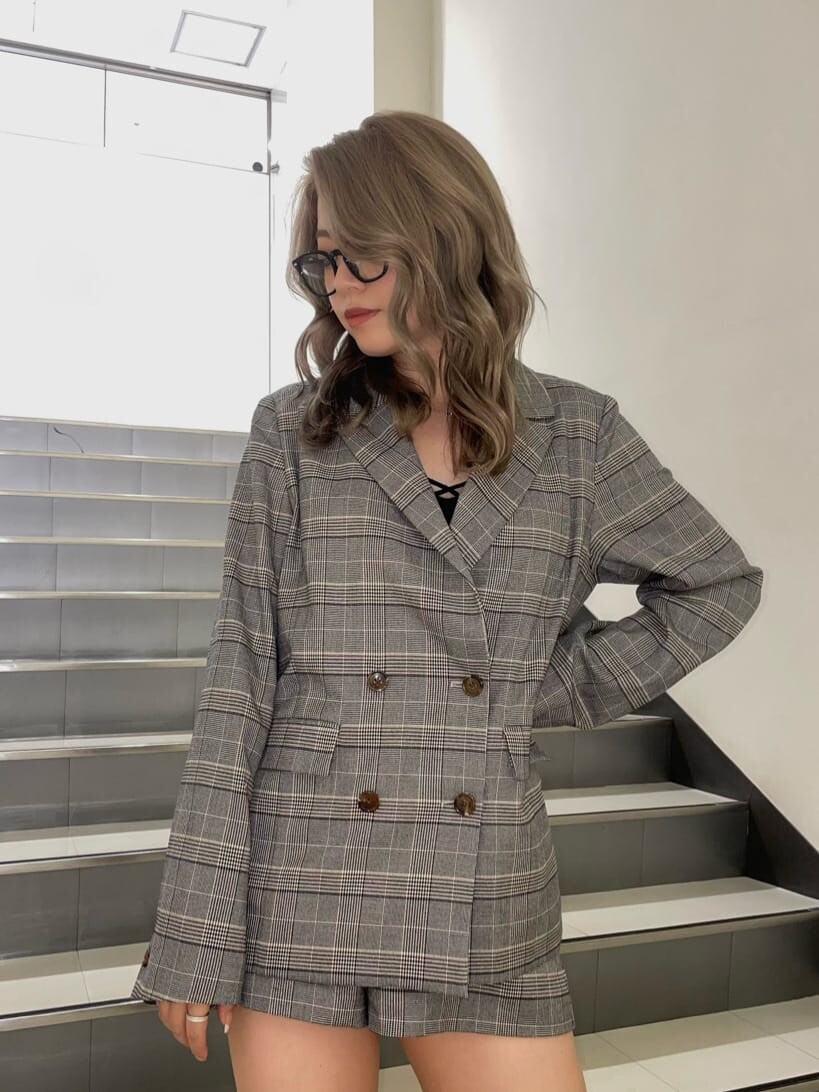 ブラック系のブーツ、ブラック系のキャミソール、ベージュ系のテーラードジャケットを着用したレディースの夏コーディネートの5枚目の写真