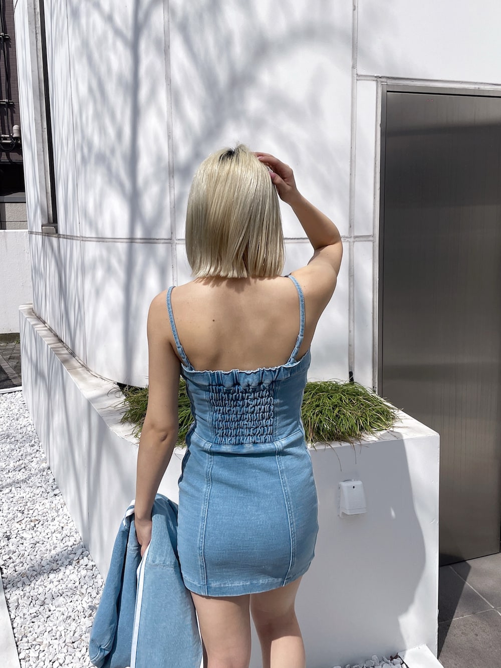 ブルー系のブルゾン、ブルー系のワンピース、ブラック系のブーツを着用したレディースの春コーディネートの4枚目の写真