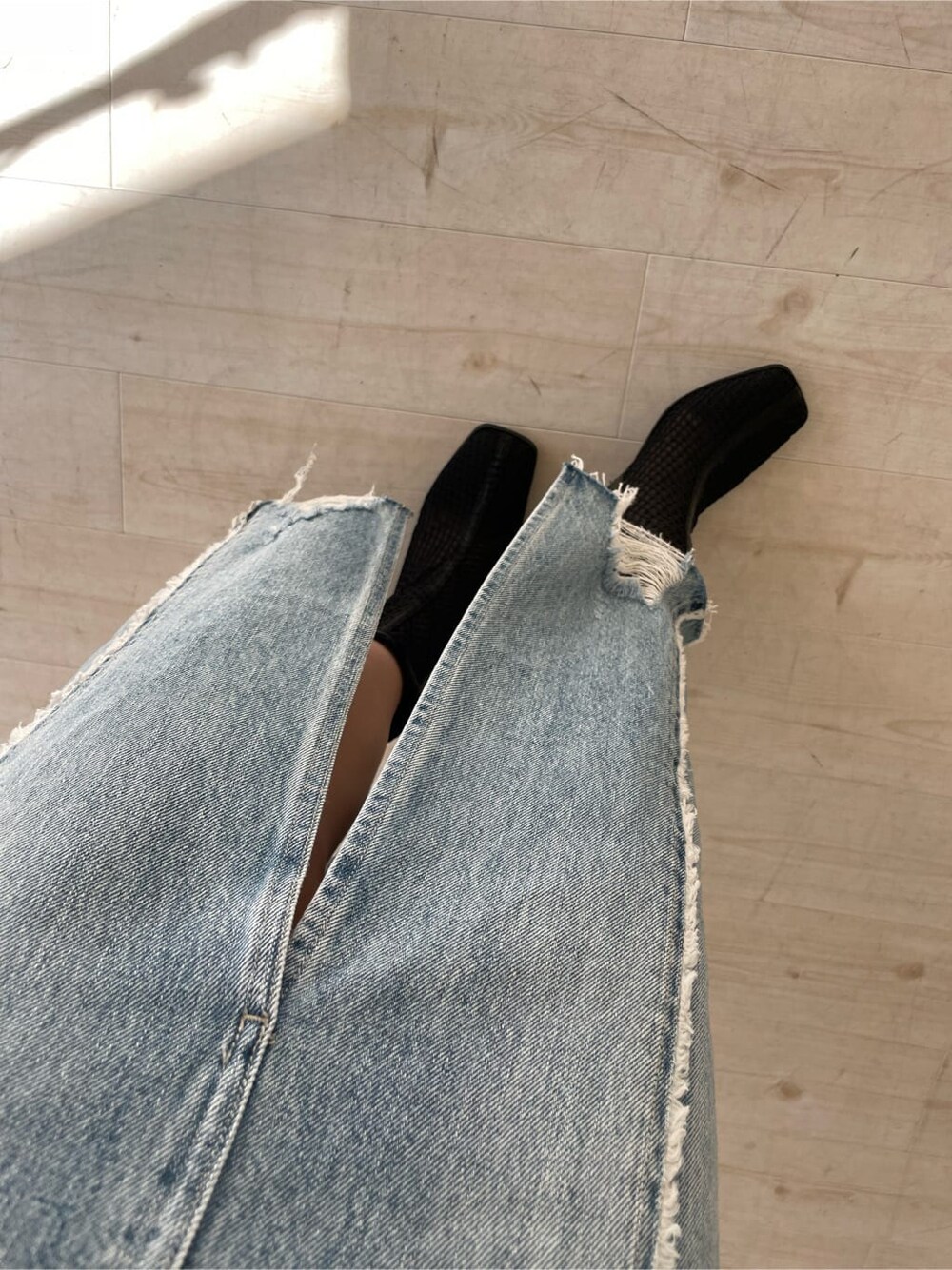 ブラック系のブーツ、グレー系のパーカー、ブルー系のデニムスカートを着用したレディースの冬コーディネートの9枚目の写真