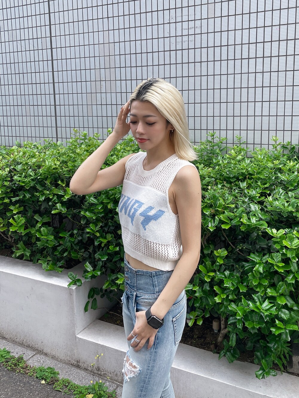 ブルー系のデニムパンツ、ホワイト系のサンダル、ホワイト系のタンクトップを着用したレディースの夏コーディネートの3枚目の写真