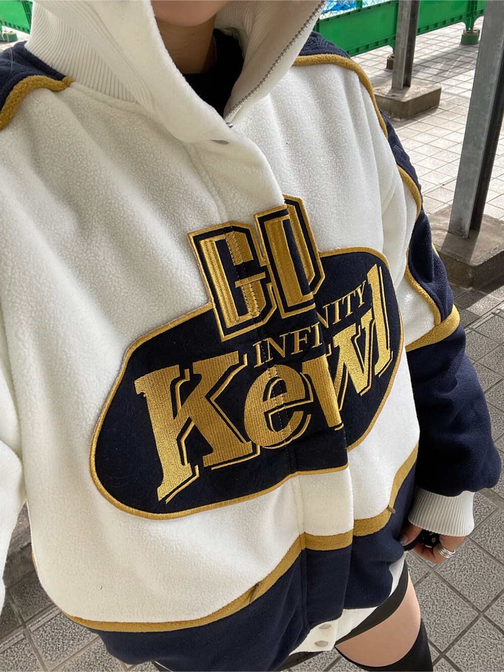 ホワイト系のブルゾン、ブラック系のブーツを着用したレディースの秋コーディネートの5枚目の写真