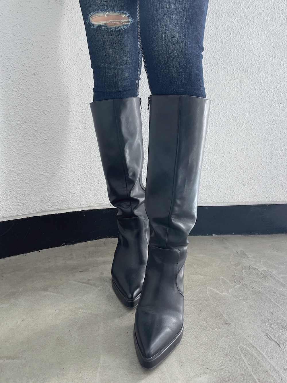 ブラック系のブーツ、ブルー系のデニムパンツ、ブラック系のニット/セーターを着用したレディースの冬コーディネートの6枚目の写真