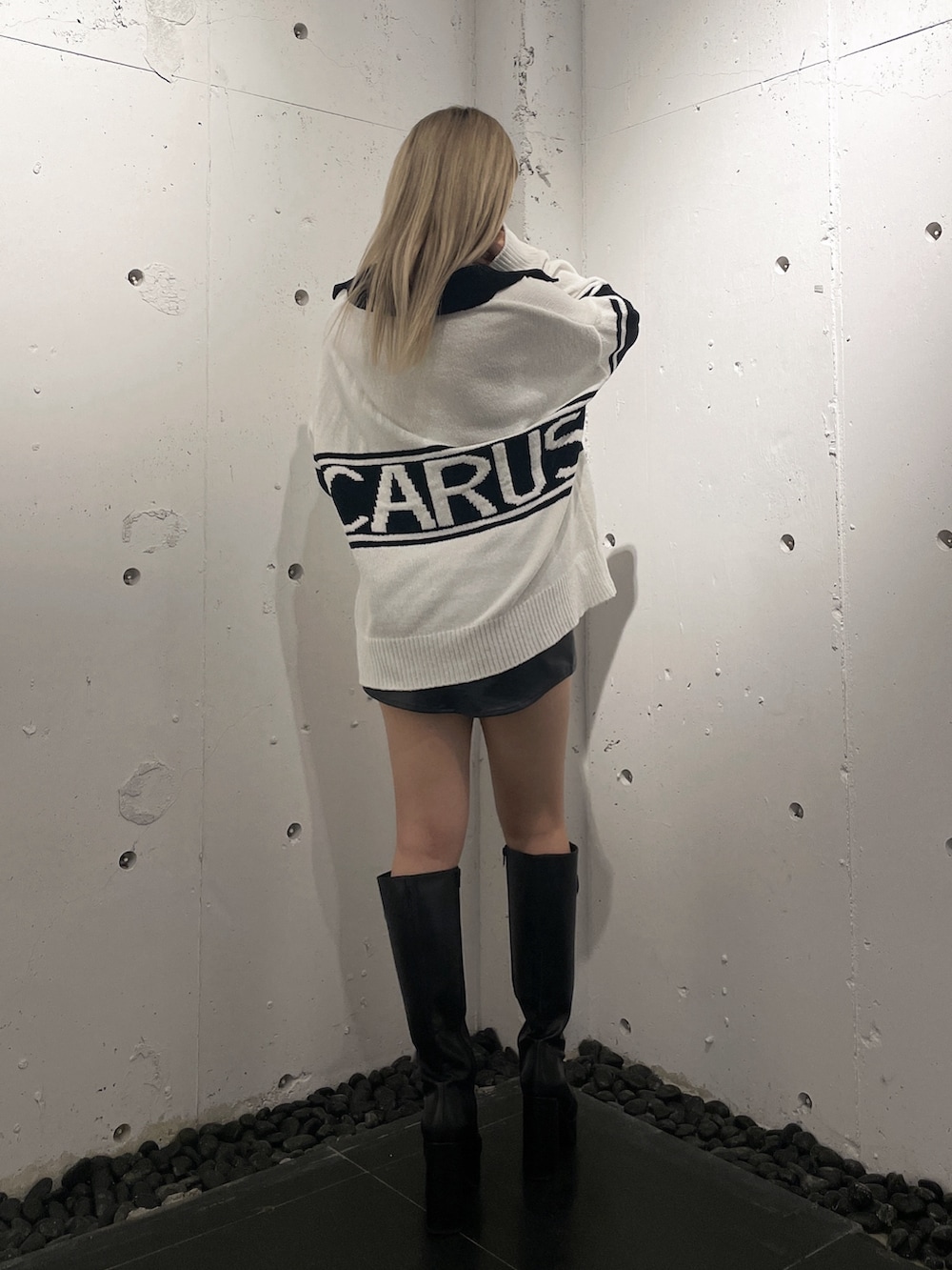 ホワイト系のニット/セーター、ブラック系のスカート、ブラック系のブーツを着用したレディースの秋コーディネートの3枚目の写真