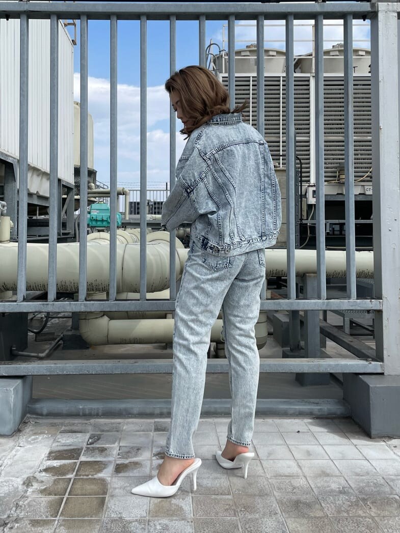 ホワイト系のパンプス、ホワイト系のキャミソール、ブルー系のデニムジャケットを着用したレディースの春コーディネートの3枚目の写真