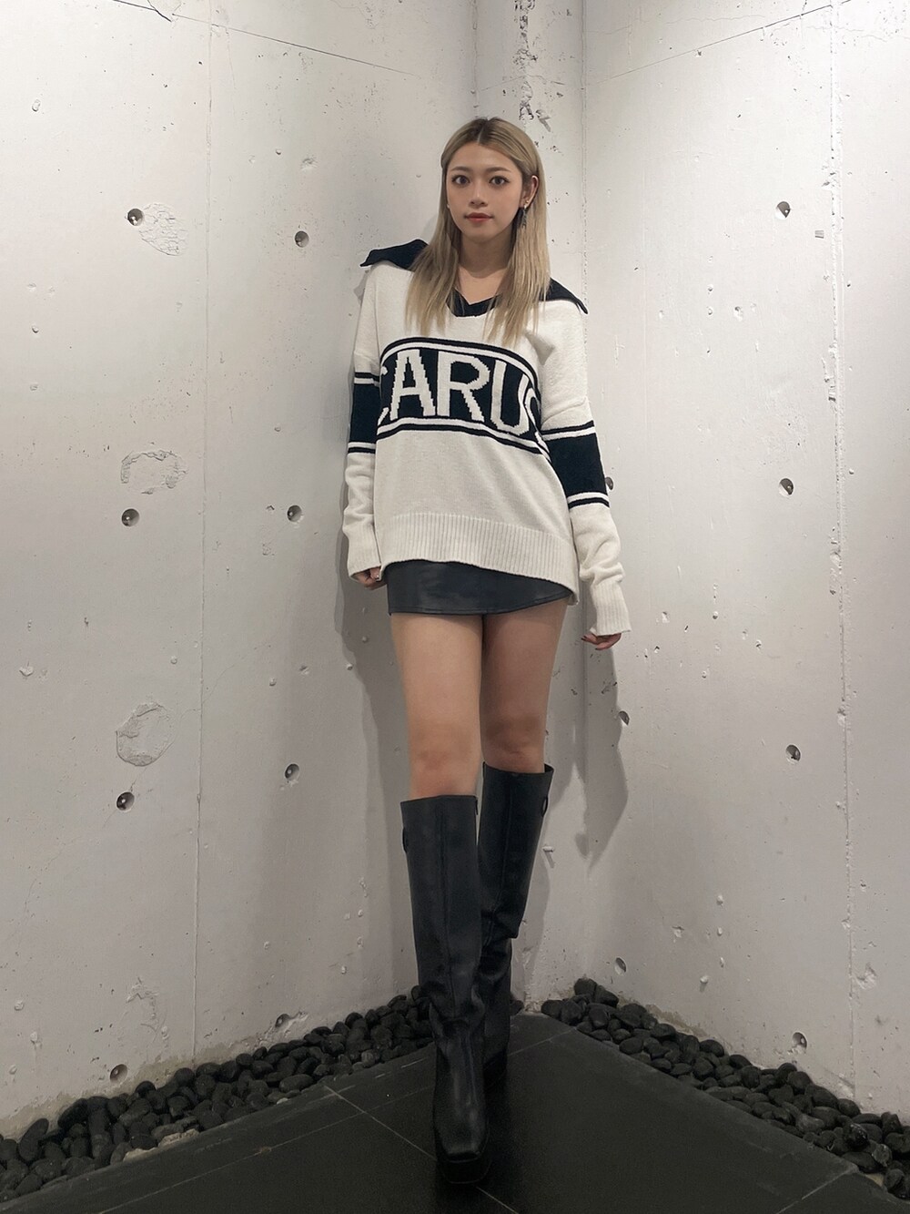 ホワイト系のニット/セーター、ブラック系のスカート、ブラック系のブーツを着用したレディースの秋コーディネートの2枚目の写真