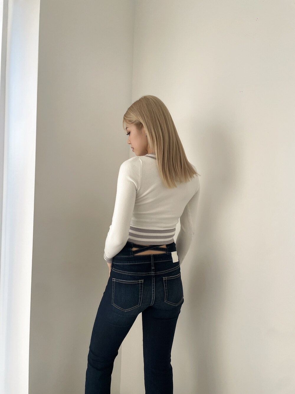 ホワイト系のニット/セーター、ブルー系のデニムパンツ、ブラック系のブーツを着用したレディースの冬コーディネートの5枚目の写真