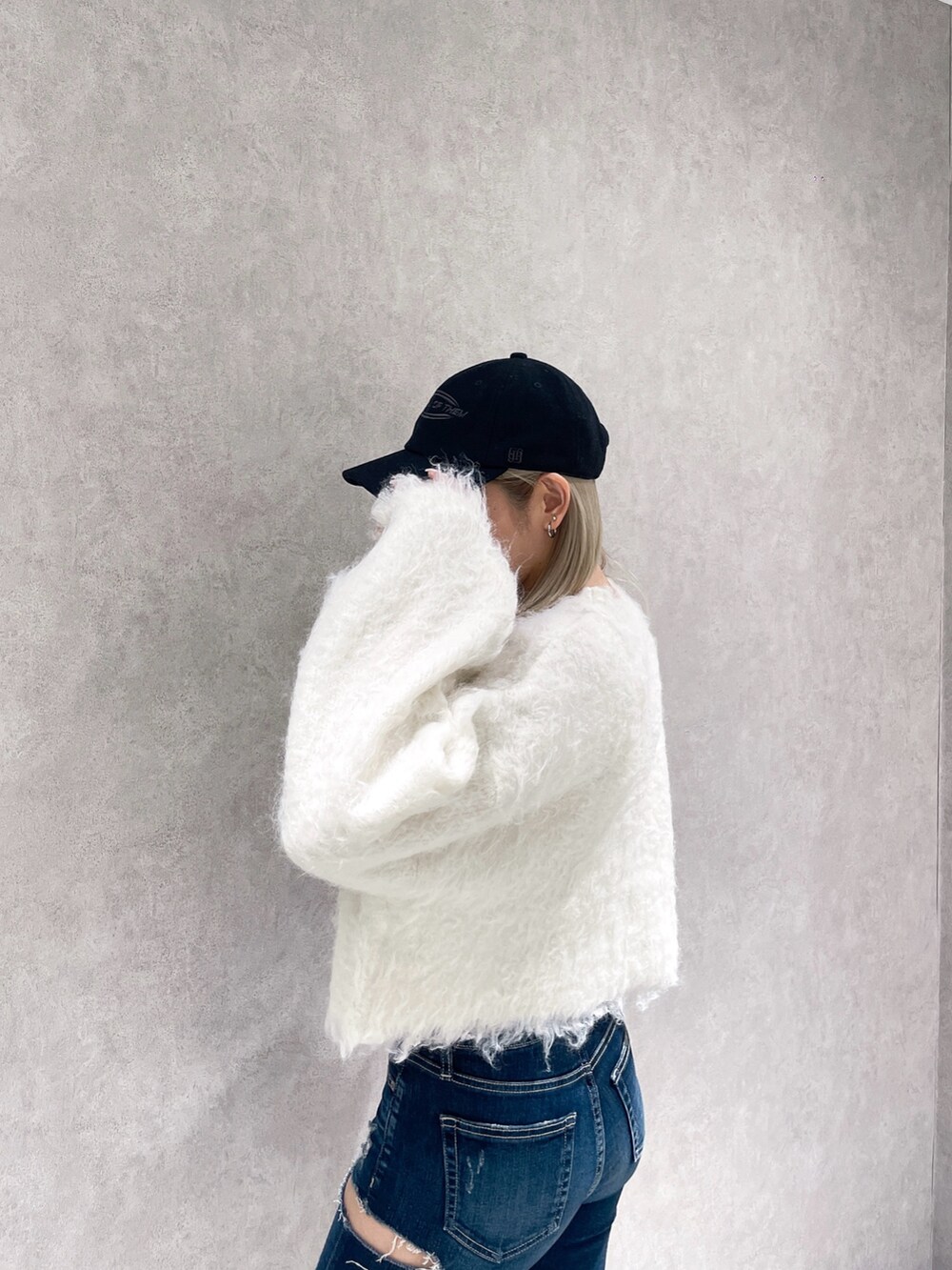 ホワイト系のニット/セーター、ブルー系のデニムパンツ、ブラック系のブーツを着用したレディースの冬コーディネートの3枚目の写真