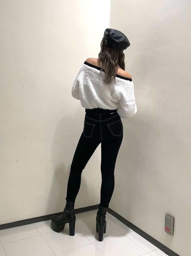 ブラック系のデニムパンツ、ブラック系のブーツ、ホワイト系のTシャツ/カットソーを着用したレディースの秋コーディネートの3枚目の写真