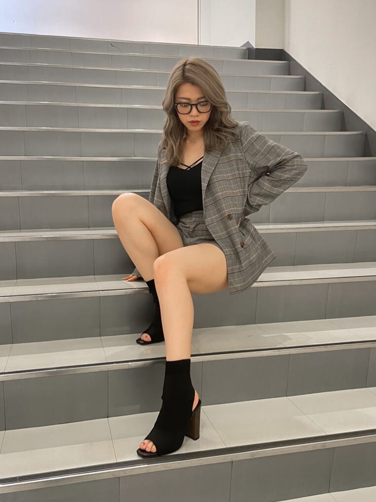 ブラック系のブーツ、ブラック系のキャミソール、ベージュ系のテーラードジャケットを着用したレディースの夏コーディネートの2枚目の写真