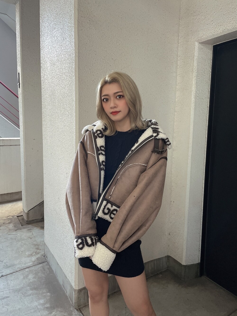 ブラック系のワンピース、ブラック系のブーツを着用したレディースの秋コーディネートの5枚目の写真