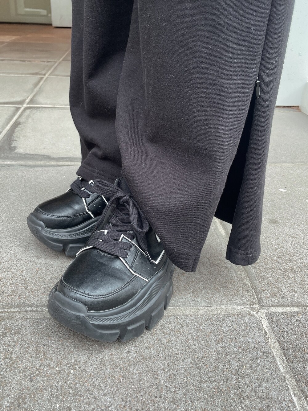 ブラック系のパーカー、ブラック系のスウェットパンツ、ブラック系のスニーカーを着用したレディースの冬コーディネートの7枚目の写真