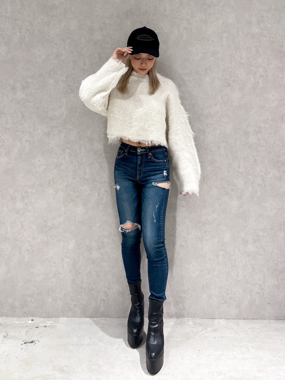 ホワイト系のニット/セーター、ブルー系のデニムパンツ、ブラック系のブーツを着用したレディースの冬コーディネートの2枚目の写真