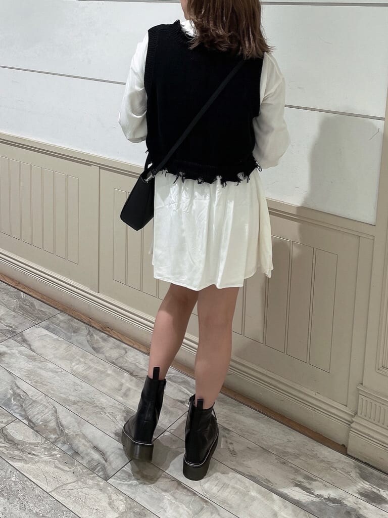 ホワイト系のワンピース、ブラック系のブーツ、ブラック系のショルダーバッグを着用したレディースの秋コーディネートの2枚目の写真