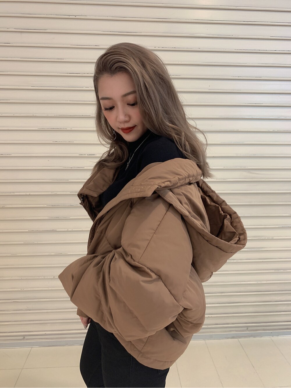 ブラック系のデニムパンツ、その他のダウンジャケット/コート、ブラック系のニット/セーターを着用したレディースの秋コーディネートの2枚目の写真