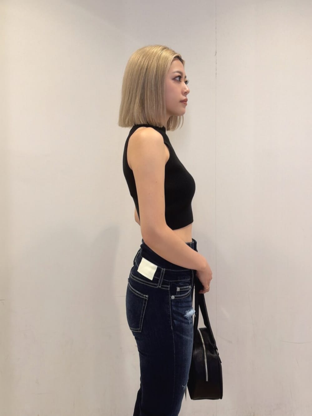 ブラック系のサンダル、ブルー系のデニムパンツ、ブラック系のニット/セーターを着用したレディースの夏コーディネートの5枚目の写真