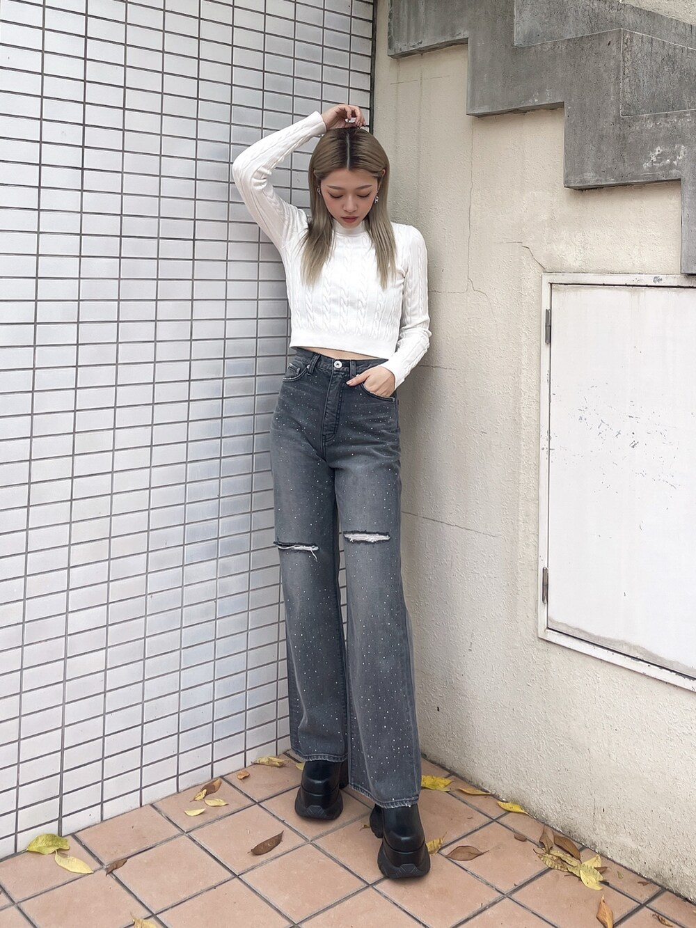 ホワイト系のニット/セーター、ブラック系のデニムパンツを着用したレディースの秋コーディネートの2枚目の写真