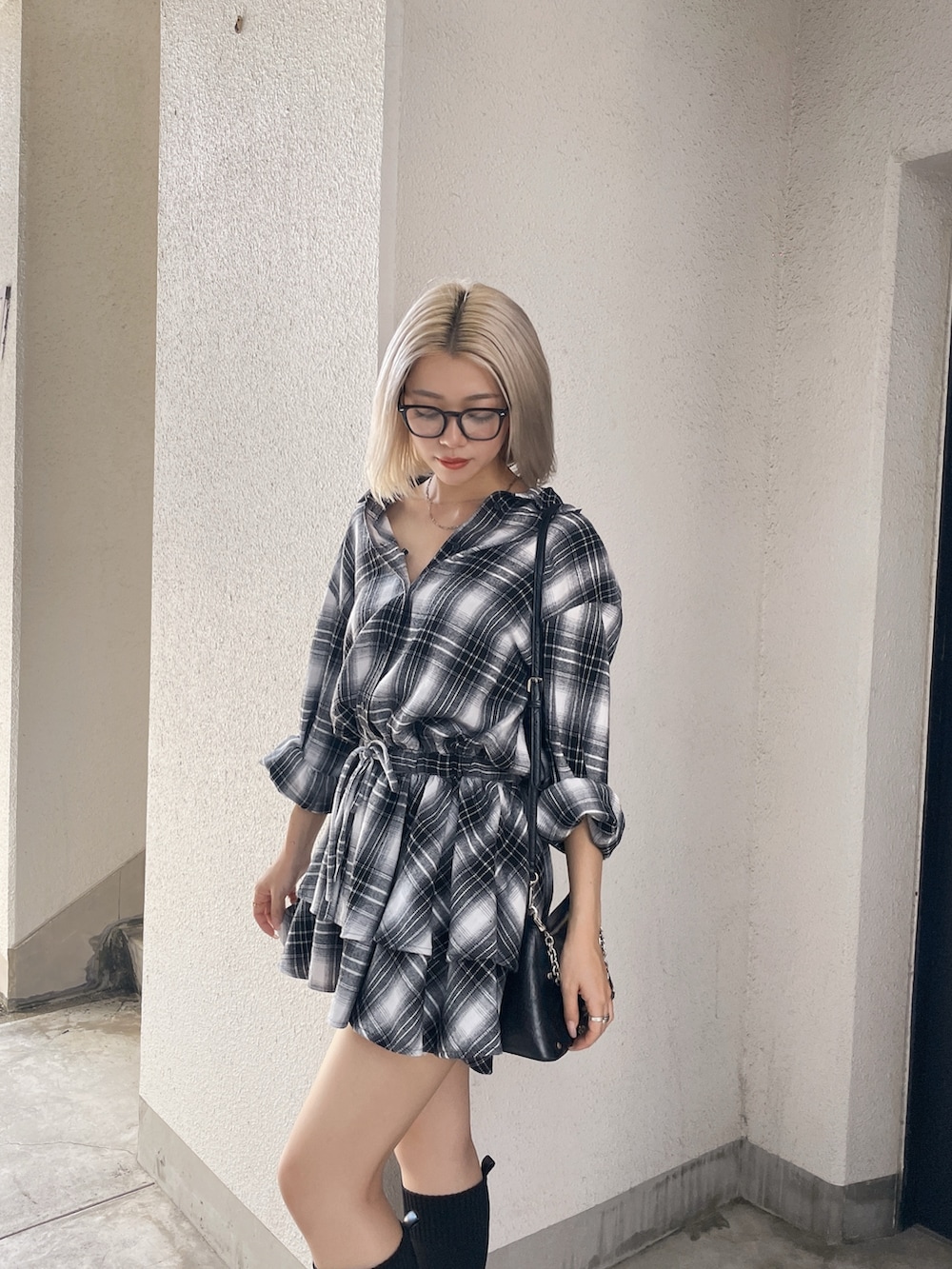 ブラック系のワンピース、ブラック系のブーツを着用したレディースの秋コーディネートの2枚目の写真