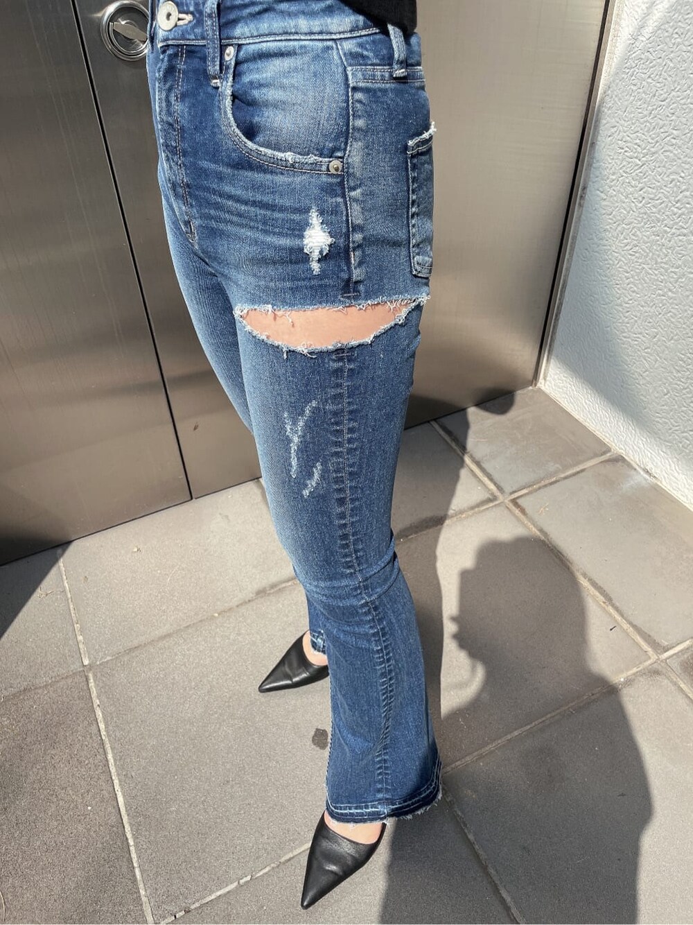 ブラック系のパンプス、ブルー系のデニムパンツ、ブラック系のニット/セーターを着用したレディースの春コーディネートの6枚目の写真