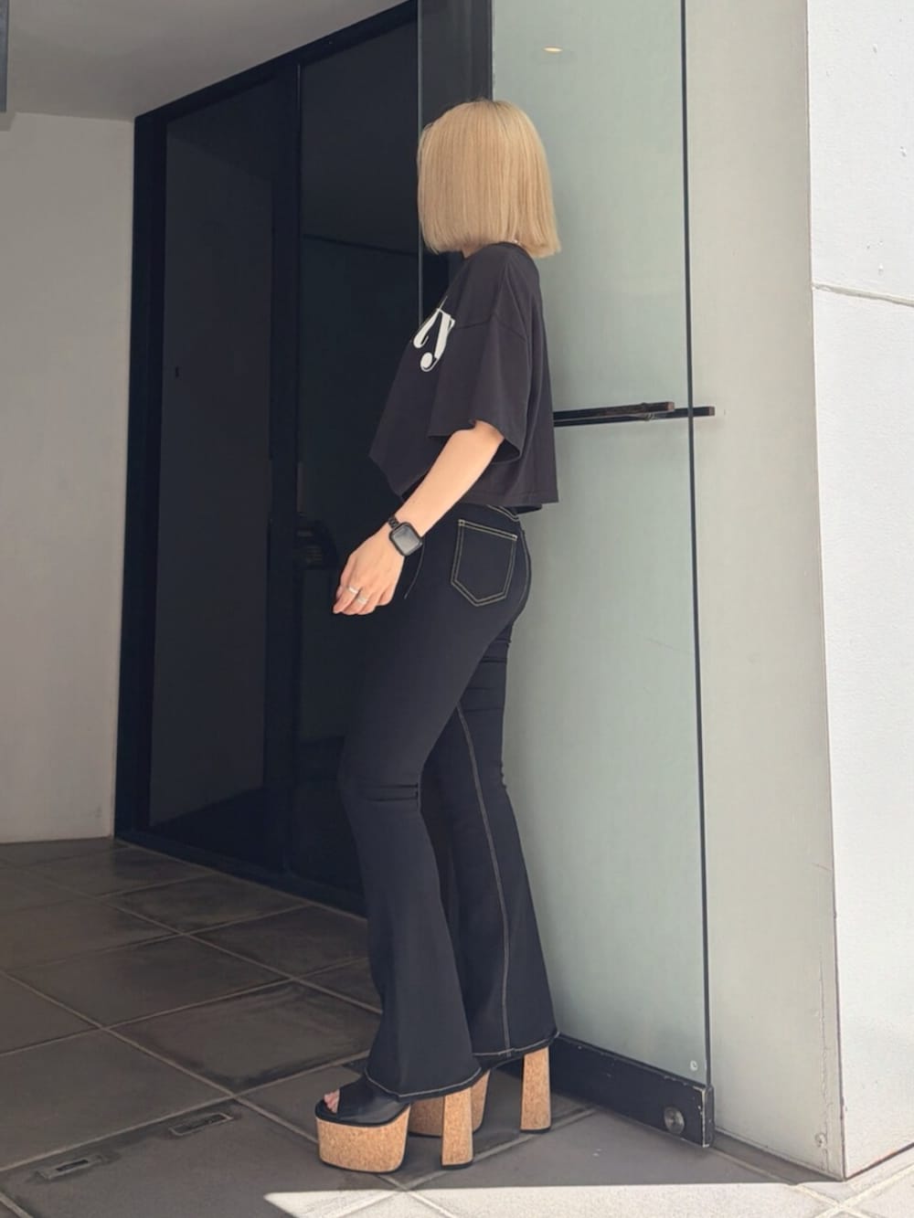 ブラック系のサンダル、ブラック系のTシャツ/カットソー、ブラック系のデニムパンツを着用したレディースの夏コーディネートの2枚目の写真