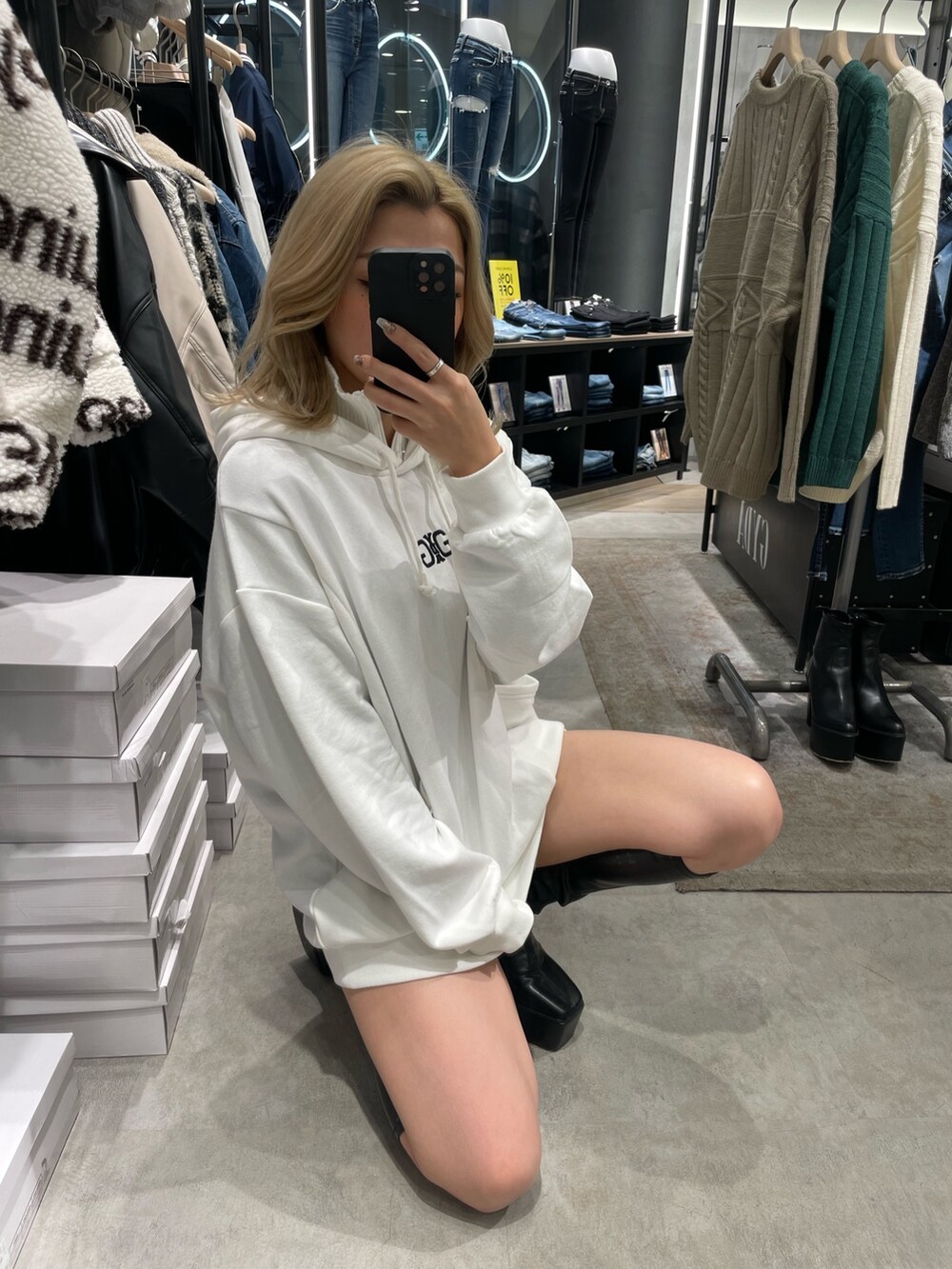 ホワイト系のスウェット、ブラック系のブーツを着用したレディースの秋コーディネートの2枚目の写真