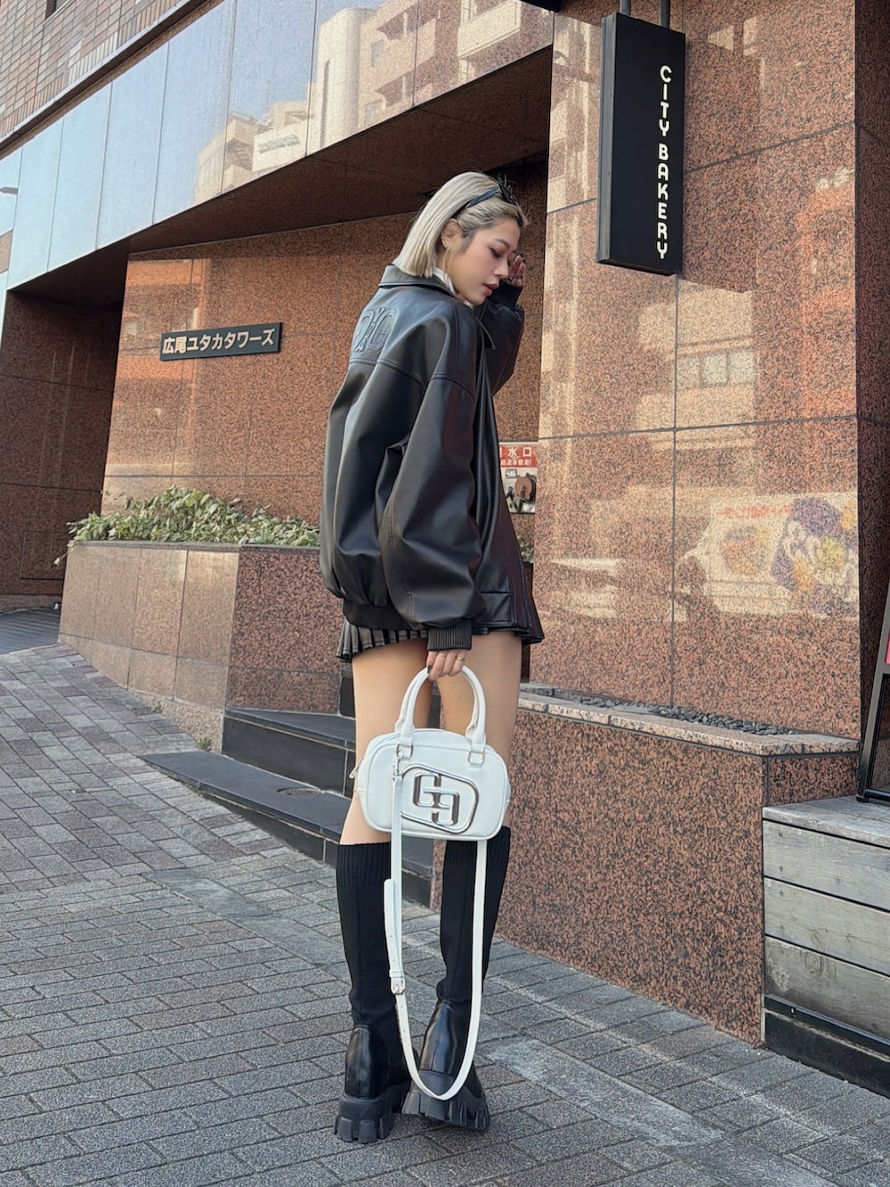 ブラック系のブルゾン、ブラック系のスカート、ブラック系のブーツを着用したレディースの冬コーディネートの3枚目の写真