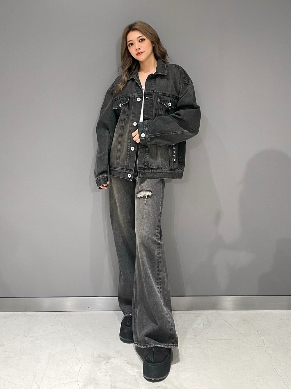 ブラック系のデニムジャケット、ブラック系のデニムパンツ、ブラック系のスリッポンを着用したレディースの秋コーディネートの2枚目の写真