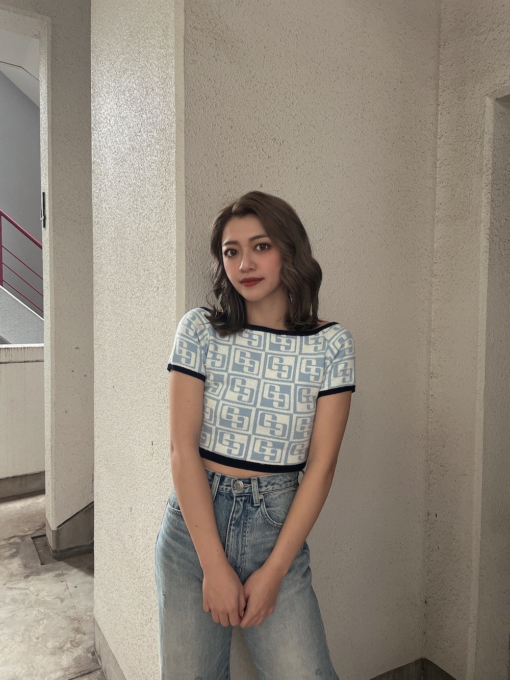 ブルー系のニット/セーター、ブルー系のデニムパンツ、ブラック系のパンプスを着用したレディースの冬コーディネートの3枚目の写真