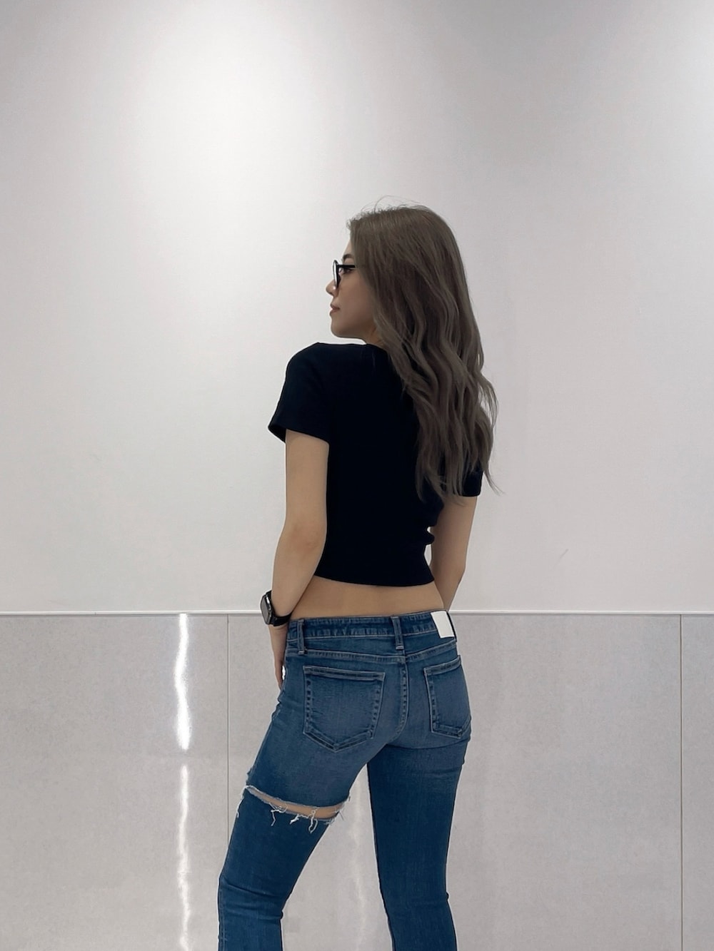 ブラック系のTシャツ/カットソー、ブルー系のデニムパンツ、ブラック系のサンダルを着用したレディースの夏コーディネートの4枚目の写真