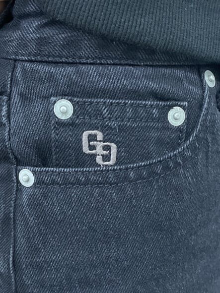 ブラック系のデニムスカート、ブラック系のブーツ、ブラック系のTシャツ/カットソーを着用したレディースの秋コーディネートの8枚目の写真