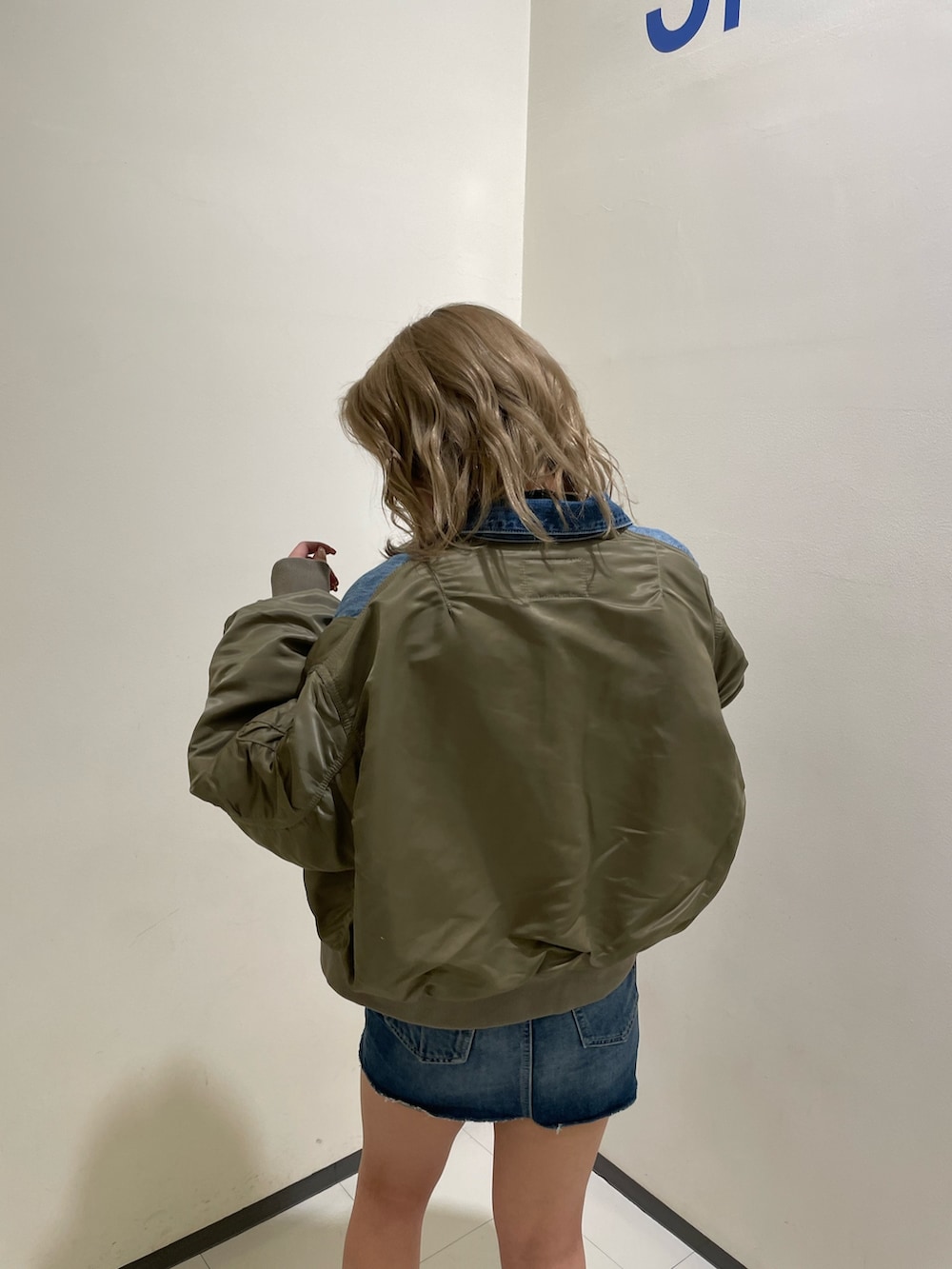 ブルー系のデニムスカート、ブラック系のブーツ、ブラック系のTシャツ/カットソーを着用したレディースの冬コーディネートの5枚目の写真