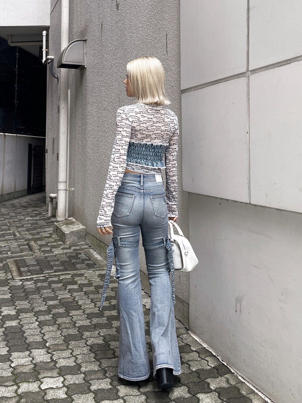 ホワイト系のTシャツ/カットソー、ブルー系のデニムパンツ、ブラック系のブーツを着用したレディースの夏コーディネートの3枚目の写真