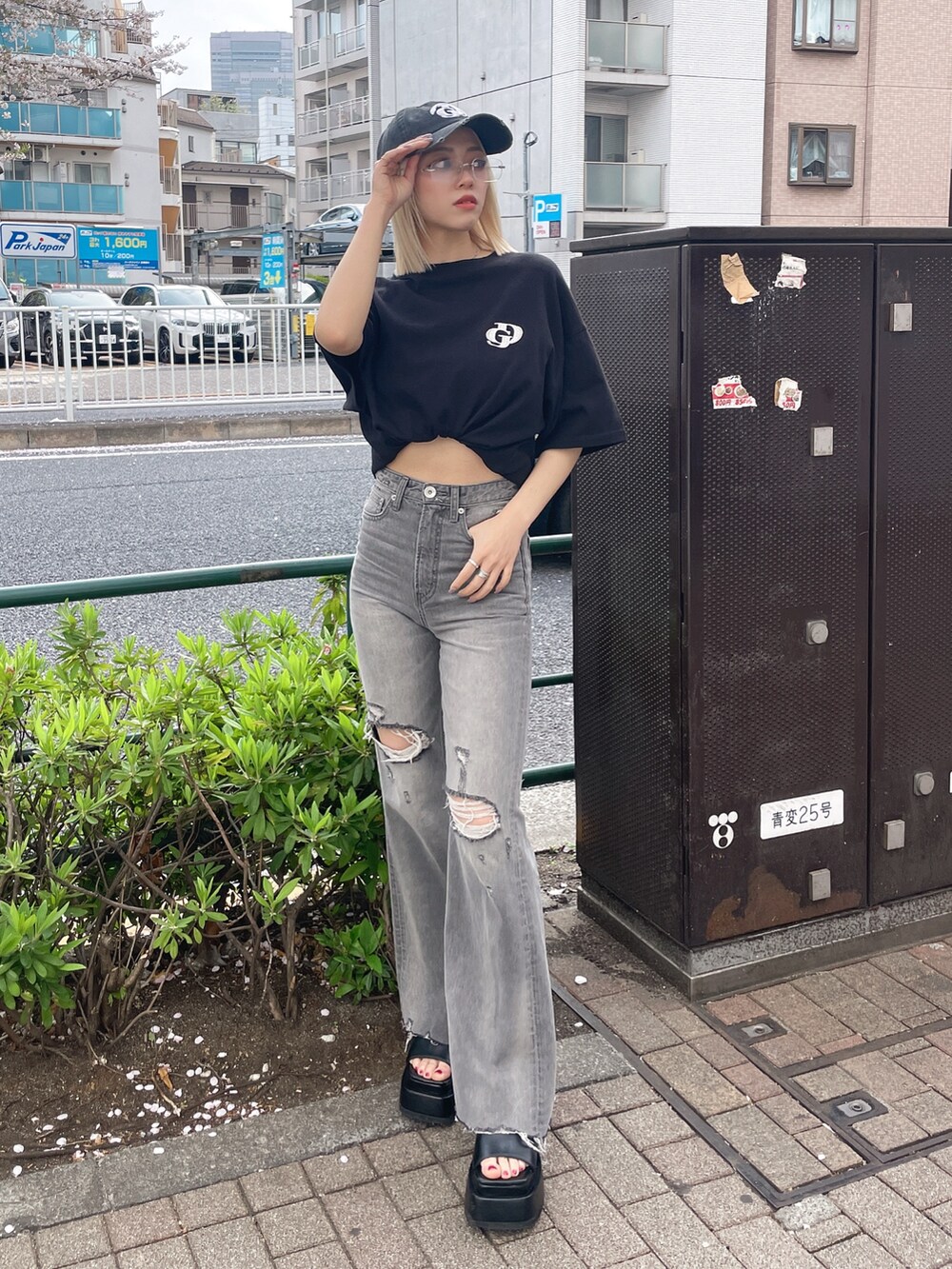 ブラック系のTシャツ/カットソー、グレー系のデニムパンツ、ブラック系のサンダルを着用したレディースの春コーディネートの3枚目の写真