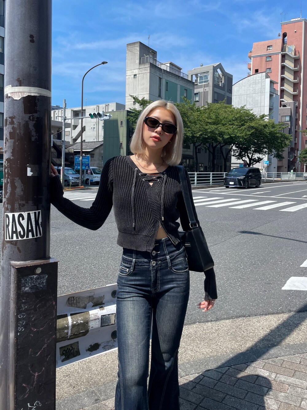 ブラック系のニット/セーター、ブルー系のデニムパンツ、ブラック系のブーツを着用したレディースの秋コーディネートの4枚目の写真