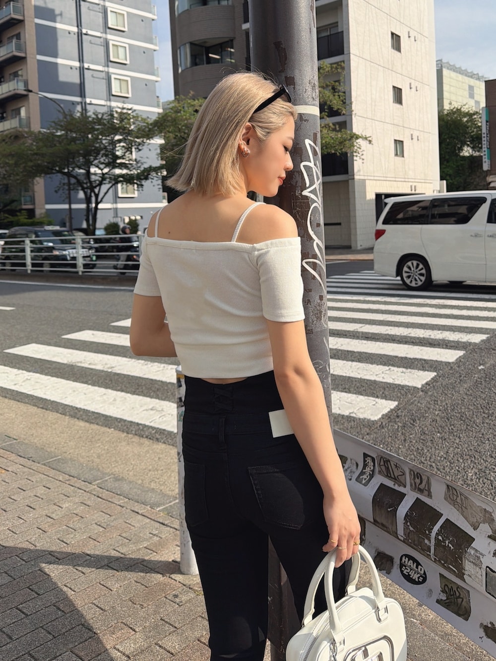 ホワイト系のTシャツ/カットソー、ブラック系のデニムパンツ、ホワイト系のサンダルを着用したレディースの春コーディネートの3枚目の写真