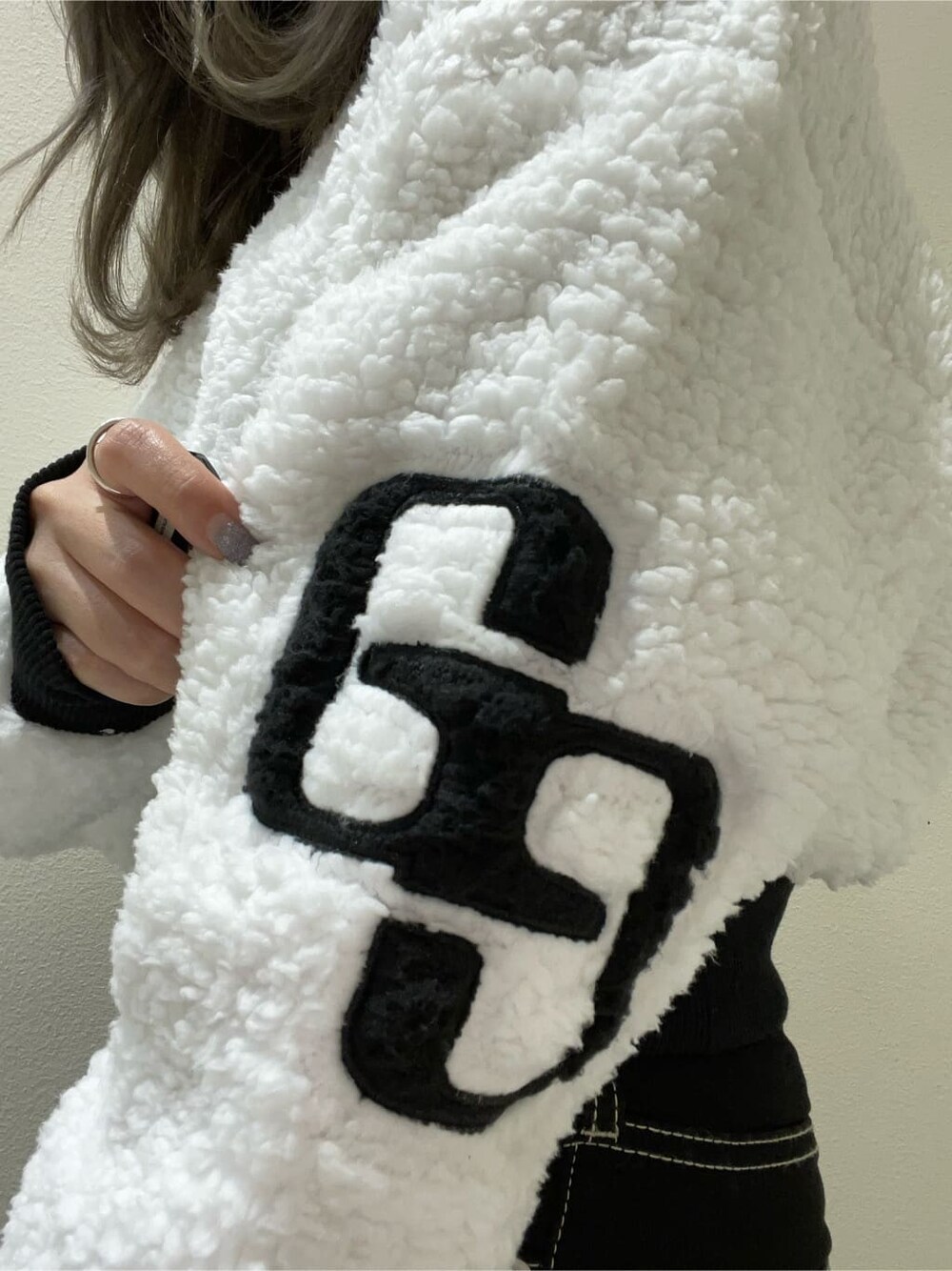 ブラック系のデニムパンツ、ブラック系のブーツ、ホワイト系のTシャツ/カットソーを着用したレディースの秋コーディネートの5枚目の写真