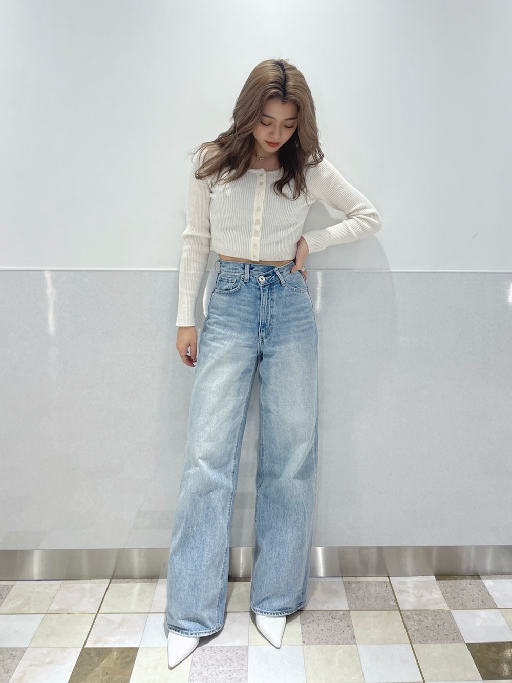 ホワイト系のカーディガン/ボレロ、ブルー系のデニムパンツ、ホワイト系のパンプスを着用したレディースの冬コーディネートの2枚目の写真