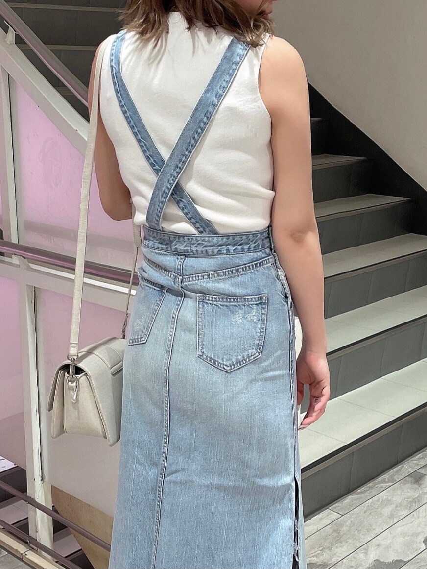 ブルー系のジャンパースカート、ベージュ系のサンダル、ホワイト系のニット/セーターを着用したレディースの春コーディネートの5枚目の写真