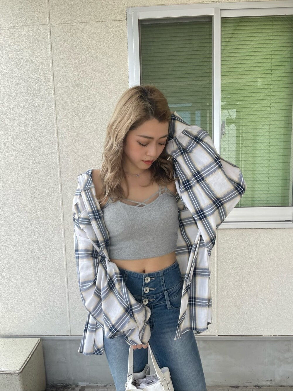 ホワイト系のシャツ/ブラウス、ホワイト系のハンドバッグ、ブルー系のデニムパンツを着用したレディースの夏コーディネートの4枚目の写真