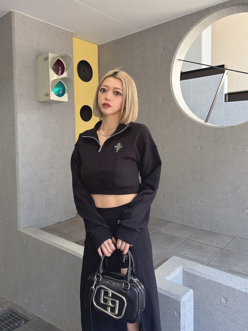 ブラック系のスウェット、ブラック系のスカート、ブラック系のハンドバッグを着用したレディースの冬コーディネートの2枚目の写真