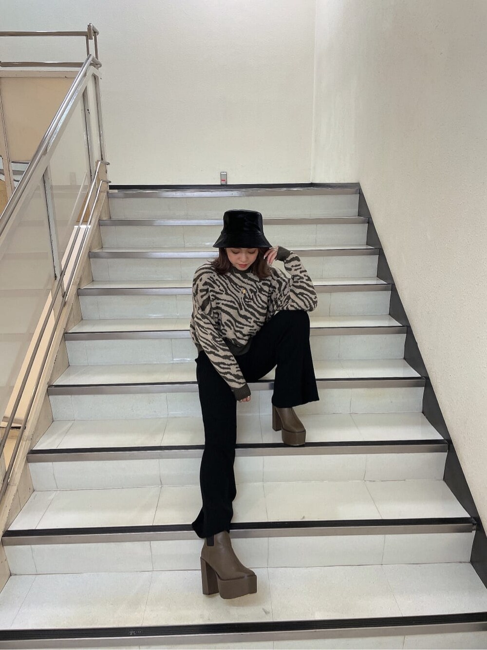ベージュ系のブーツ、ブラック系のその他パンツ、ベージュ系のニット/セーターを着用したレディースの秋コーディネートの2枚目の写真