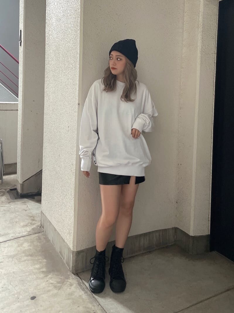 ブラック系のブーツ、ブラック系のスカート、ホワイト系のTシャツ/カットソーを着用したレディースの秋コーディネートの2枚目の写真